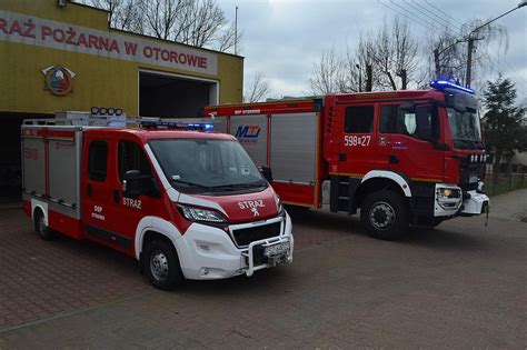 Ilustracja przedstawiająca strażaków OSP w Łęce Opatowskiej podczas uroczystości jubileuszowej.