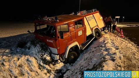 Dachujący wóz strażacki w przydrożnym rowie na śliskiej, zimowej drodze