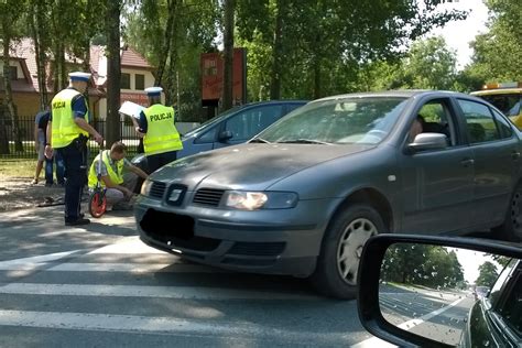 Strażacy sprzątający jezdnię po wypadku drogowym, usuwający plamy oleju i szkło