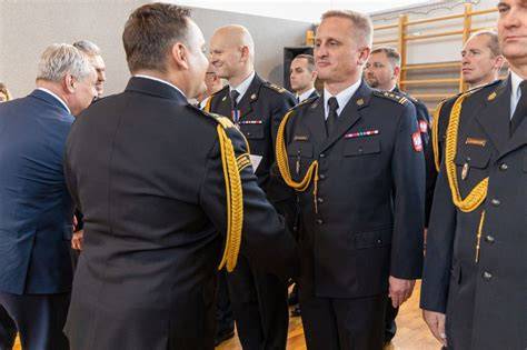 Tematyczne zdjęcie strażaków OSP w galowych mundurach podczas uroczystości