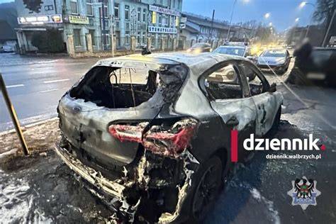 Spalony samochód Audi na parkingu przy ulicy Łasaka