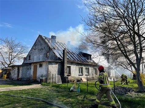 zdjęcie poglądowe działań gaśniczych straży pożarnej przy drewnianym budynku