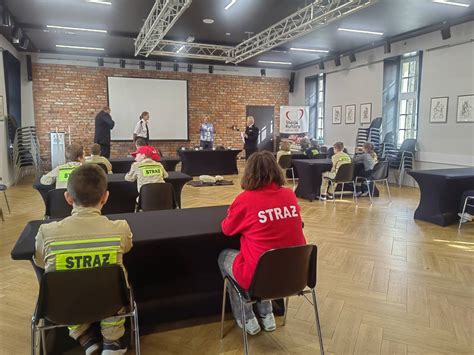Młodzież rozwiązująca test wiedzy pożarniczej oraz ćwicząca pierwszą pomoc