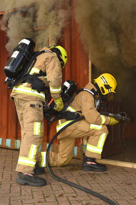 Photo of firefighters in breathing apparatus entering a smoke-filled building