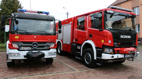 Wóz strażacki i strażacy gaszący pożar domu