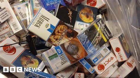 Photo of a building after a fire, possibly with police presence or seized illegal tobacco products