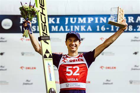 Kamil Stoch na podium olimpijskim w skokach narciarskich, cieszący się ze złotego medalu
