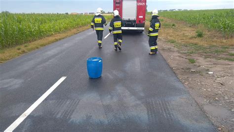 Strażacy neutralizujący plamę oleju na drodze