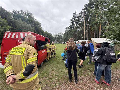 zdjęcie dzieci na obozie strażackim, śpiących w namiotach lub maszerujących przez las