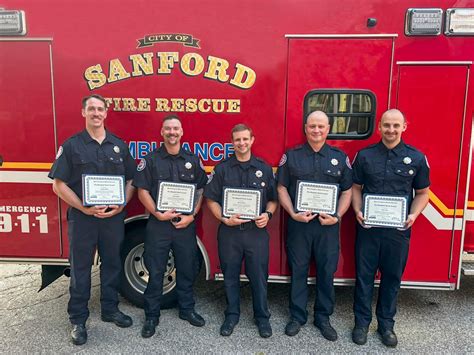 Photo of a 14-year-old boy receiving an award from firefighters.