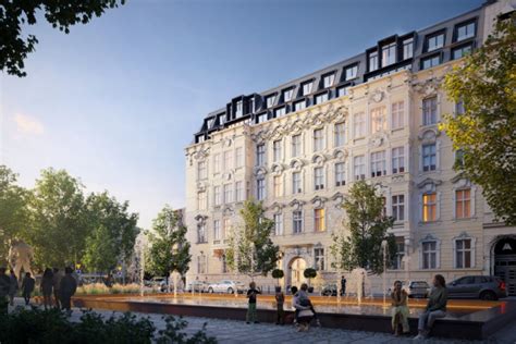 Fotografia spalonej zabytkowej kamienicy w centrum miasta, otoczonej nowoczesnymi budynkami.