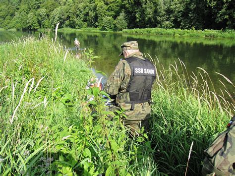 Ilustracja przedstawiająca grupę wędkarzy podczas pracy porządkowej na brzegu łowiska