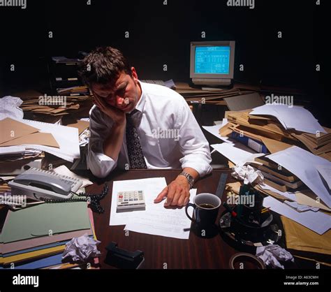 Thematic photo of a firefighter at a desk, looking stressed with paperwork and multiple phone calls