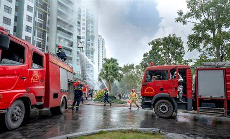 Photo of firefighters at a residential building fire scene, or emergency vehicles