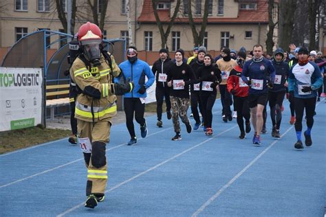 Strażacy biegnący w maratonie w pełnym umundurowaniu