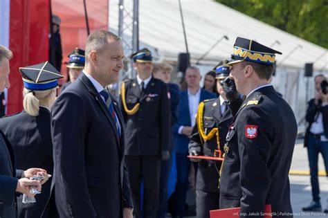 Prezydent i minister w otoczeniu awansowanych strażaków podczas uroczystości