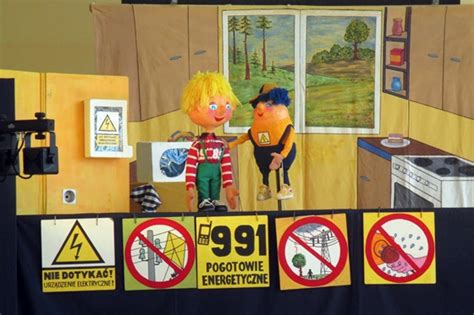 Ilustracja przyjaznego strażaka uczącego dzieci, jak bezpiecznie obchodzić się z ogniem.