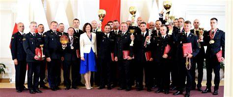 Zdjęcie z ceremonii wręczenia nagród z widocznymi strażakami i dziećmi