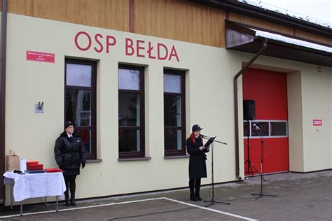Portret Wojciecha Kuczyńskiego na tle remizy OSP Bełda