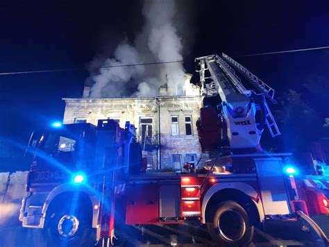 Strażacy gaszący pożar zabytkowej kamienicy