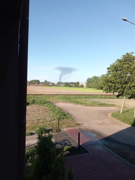 Zdjęcie ukazujące słup dymu widoczny z daleka nad polami