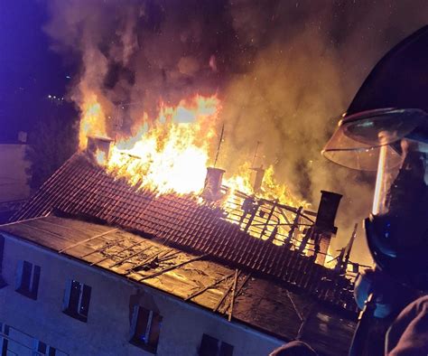 Strażacy gaszący pożar dachu kamienicy przy Alei Warszawskiej w Olsztynie