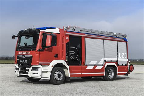 Thematic photo of a modern fire truck (MAN TGM 18.320 4x4) at an official handover ceremony, with firefighters and community representatives.