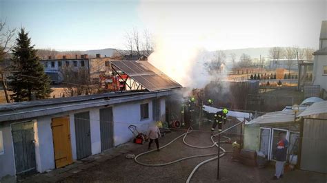 Zdjęcie przedstawiające pożar budynku gospodarczego w Tarnówce, akcję gaśniczą z udziałem wielu strażaków.