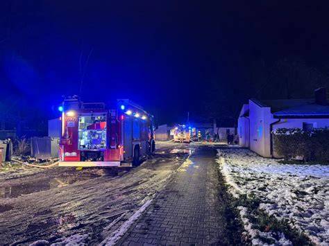 Zdjęcie nocnego pożaru budynku gospodarczego, w tle widoczne wozy strażackie