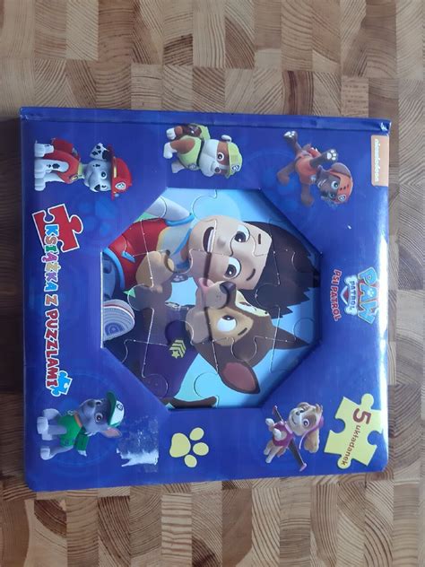 Zdjęcie kolorowego pudełka z puzzlami przedstawiającymi scenę z serialu 