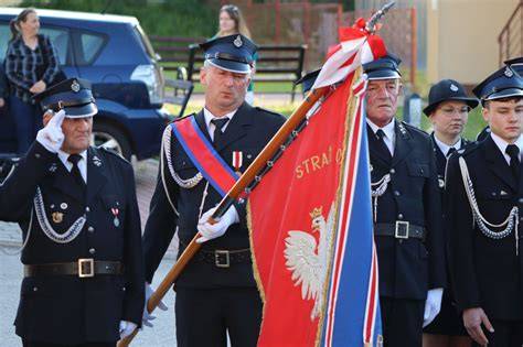 Uroczysty przemarsz strażaków z orkiestrą i pocztami sztandarowymi ulicami Warki