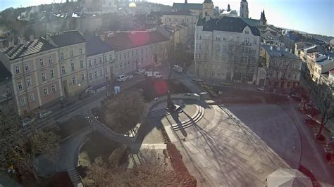 Widok na Plac Strażacki w Lubaniu, z widocznym parkingiem i otoczeniem