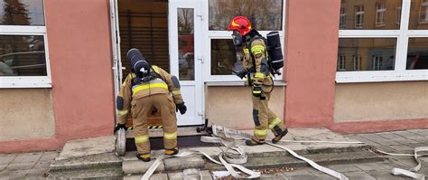 Rota strażaków przygotowująca się do wejścia do zadymionego pomieszczenia, używająca prądu rozproszonego