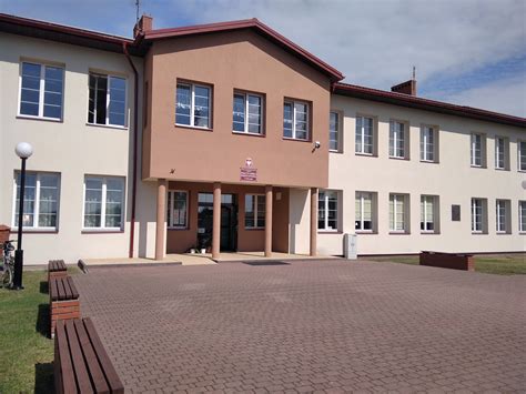 Zdjęcie przedstawiające budynek Zespołu Placówek Oświatowych w Borzęcie lub grupę uśmiechniętych uczniów
