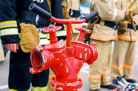 Zdjęcie typowego czerwonego hydrantu nadziemnego z tabliczką oznakowania umieszczonego na tle ulicy.