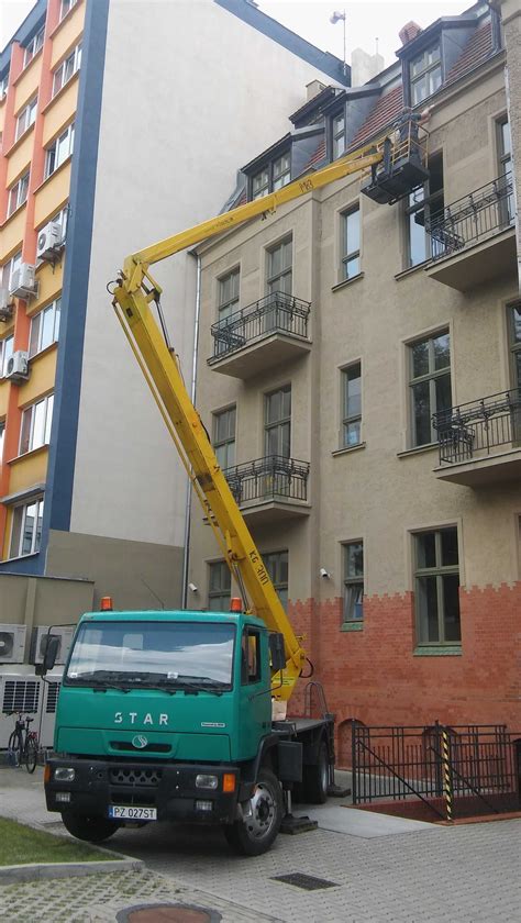 zdjęcie samochodu pożarniczego z rozłożoną drabiną obrotową lub podnośnikiem koszowym