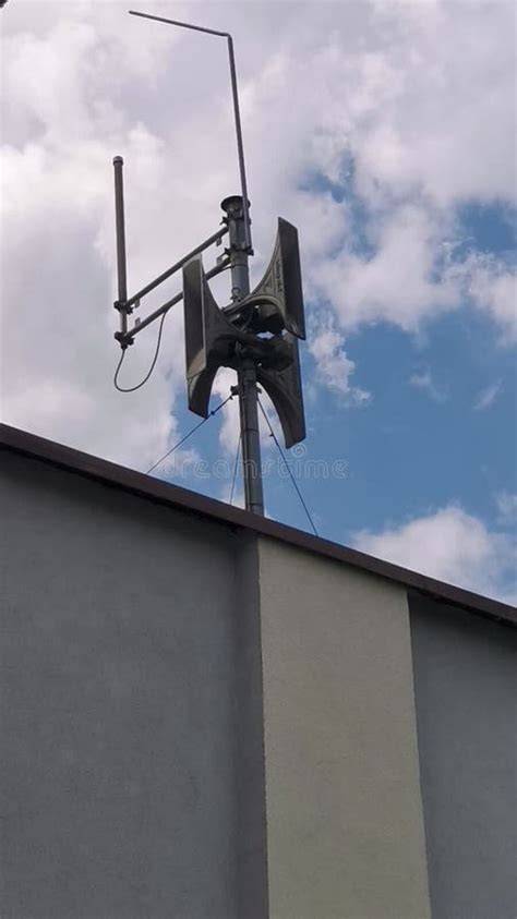 Thematic photo of a fire siren on a remiza roof against a blue sky