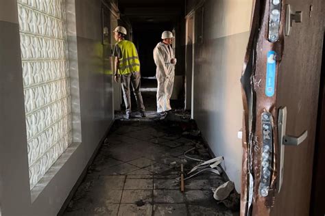 Grupa osób pomagających w sprzątaniu spalonego budynku