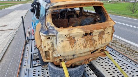 spalony Volkswagen Transporter na parkingu, widoczne uszkodzenia innych aut
