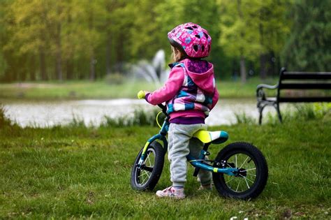 dziecko z rowerkiem biegowym w kasku Btwin 500