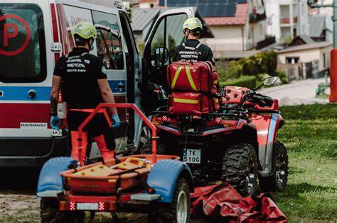 Zdjęcie przedstawiające quad ratowniczy z zamontowaną przyczepką specjalistyczną podczas działań terenowych