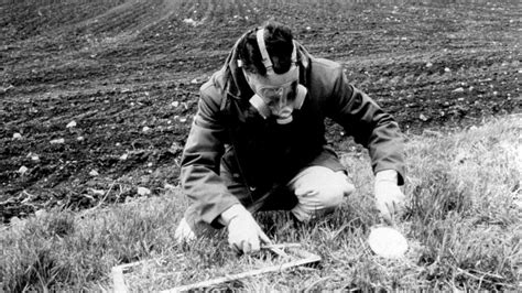 zdjęcie strażaka w masce przeciwgazowej pobierającego próbkę ziemi w Czarnobylu