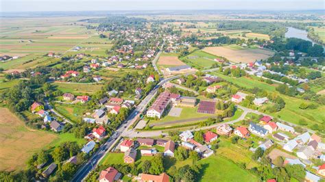 Zdjecie przedstawiajace remize strażacką w polskiej wsi, z lokalną społecznością wokół niej, symbolizujące centrum życia.