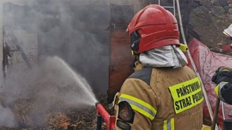 zdjęcie przedstawiające akcję gaśniczą straży pożarnej przy płonącym bloku