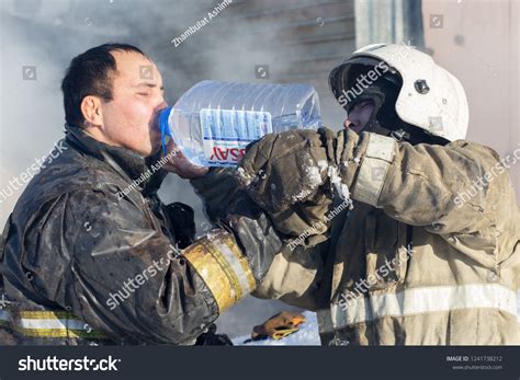 Photo of a firefighter drinking water from a bottle