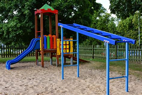 Fotografia placu zabaw z widocznymi elementami bezpieczeństwa