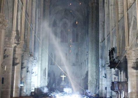 Wnętrze katedry Notre Dame po pożarze, widoczne zniszczenia dachu i sklepienia