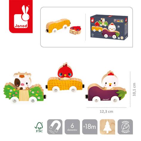 Ilustracja przedstawiająca zawartość zestawu drewnianej remizy-garażu Janod, z widocznymi pojazdami, figurkami i budynkiem remizy.
