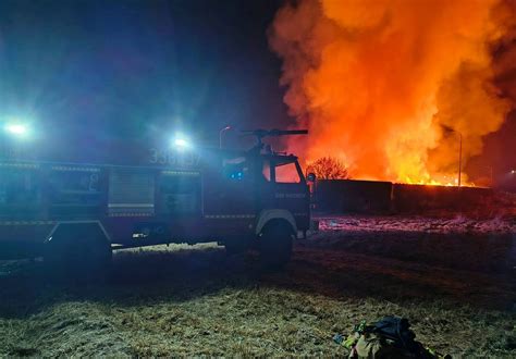 Strażacy OSP na tle wozu bojowego, gotowi do akcji