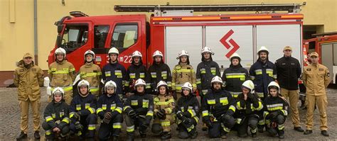 Strażacy z OSP polewający wodą mieszkańców z wozu strażackiego